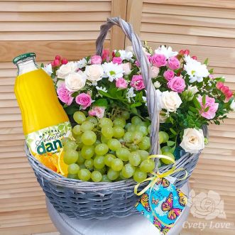Виноград, цветы и напиток в плетеной корзине